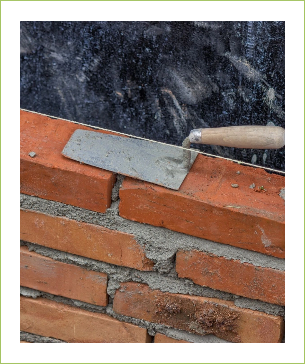 A person using a spatula to remove bricks from the wall.