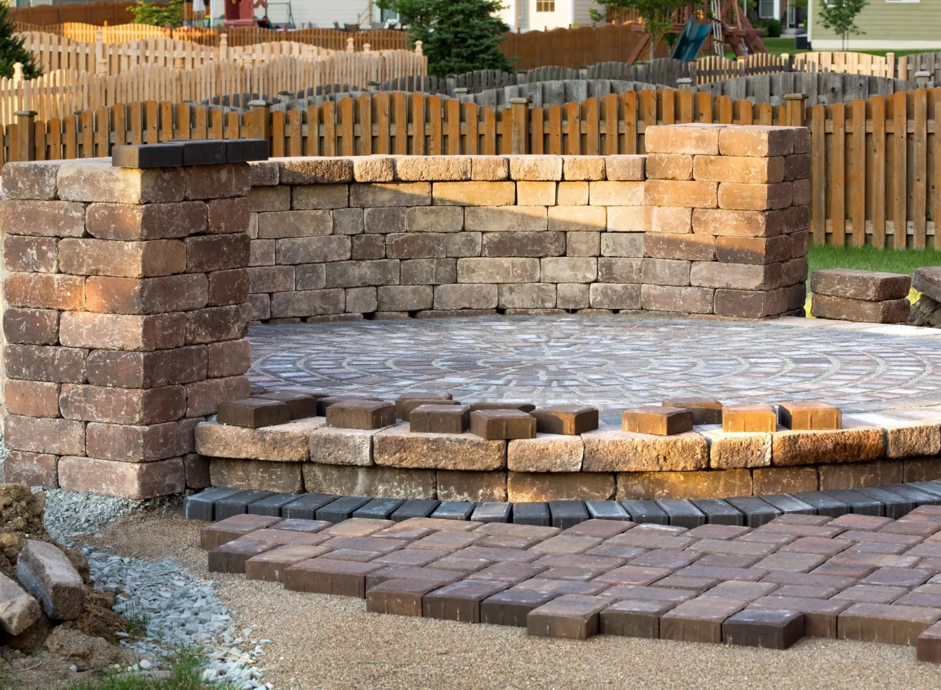 A brick patio with steps and a stone wall.