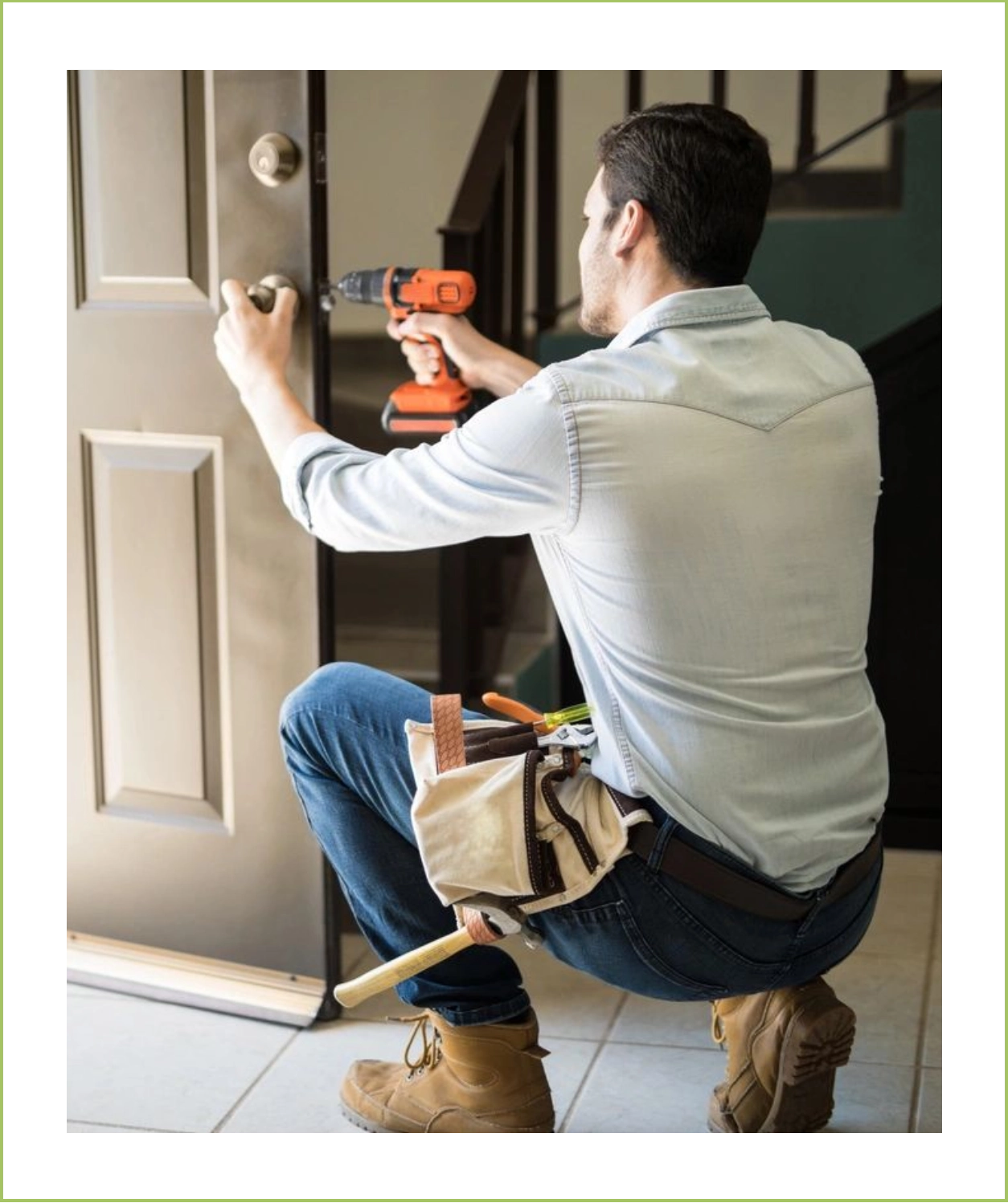 A man is holding a drill and looking at the door.