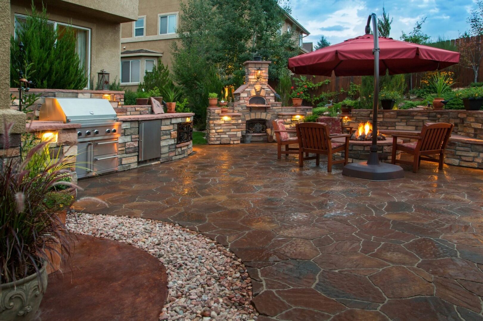 A patio with an outdoor fireplace and grill.