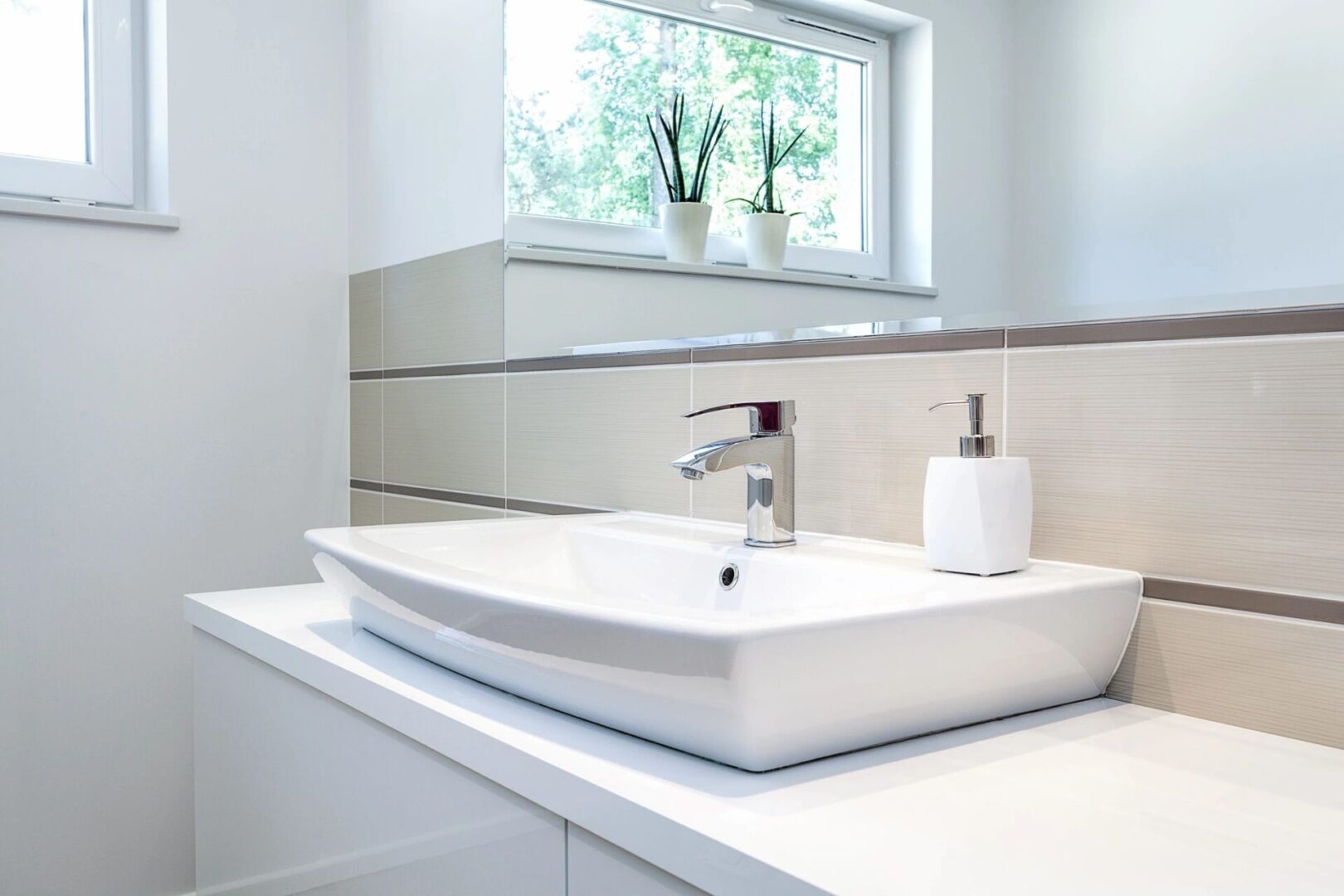 A white sink sitting under a bathroom mirror.